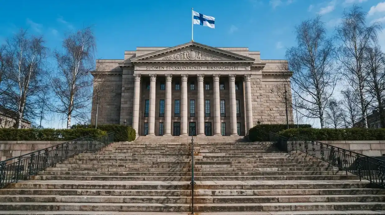 Bred granitttrapp foran en offentlig bygning med søyler og et flagg i vinden, blå himmel